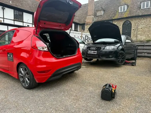 BLS Ecoboosts red Fiesta van beside an Audi A3 being worked on at a customer’s address